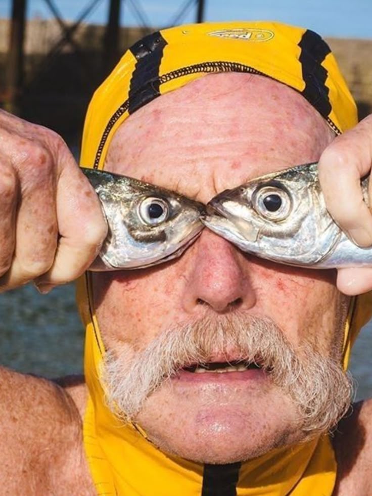 a man holding up fish as eyes